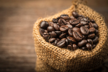 Coffee beans in sack on wood table