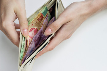 Mexico.Woman is taking pesos out of her wallet.