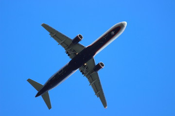 Dark blue Russian 2-motor Passenger Turbojet aircraft with chassis takes off against the blue sky close up, recreation, tourism