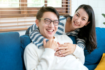 sweet lovey asian family couple sit talk good conversation on sofa in living room house background