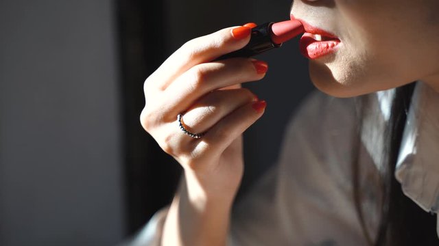 Close up young asian woman applying red lipstick on her lip, beauty and fashion lifestyle