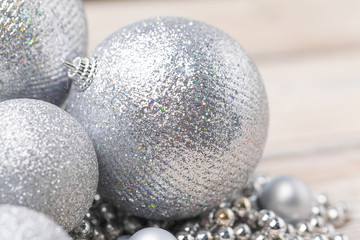 Shiny silver glitter baubles close up on wooden table