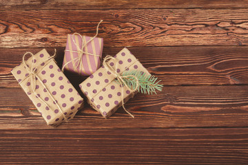 Stylish decorated christmas gifts over brown wooden background
