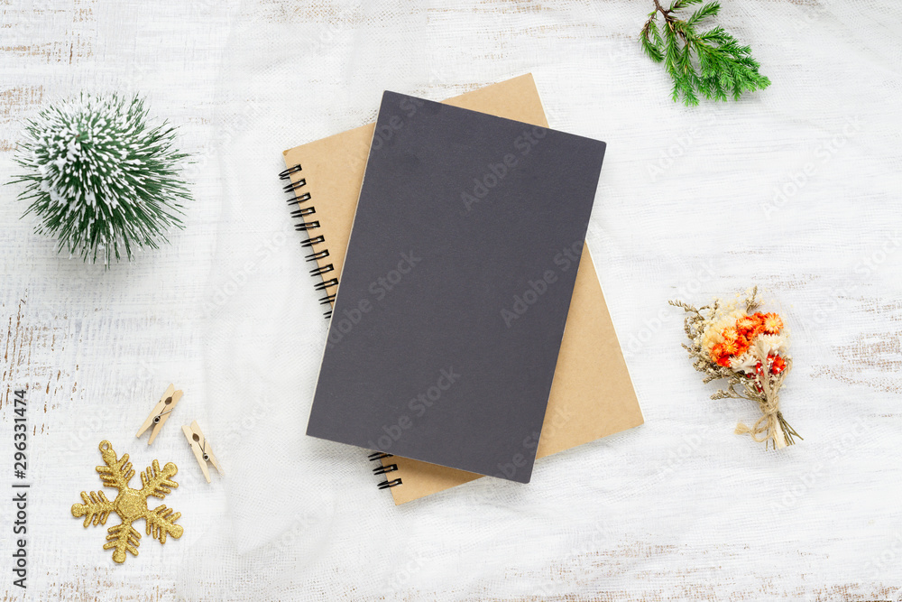 Aufkleber top view of blank cover notebook on nest fabric and white wood background with xmas decorations. moc