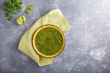 Tomatillo salsa verde. Bowl of spicy green sauce on gray table, mexican cuisine. - obrazy, fototapety, plakaty