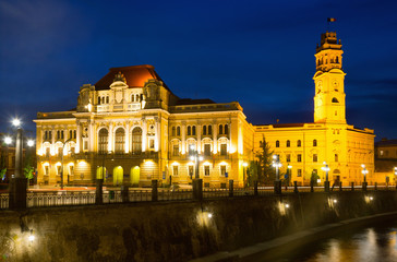 Fototapeta na wymiar Oradea City Hall on embankment in twilight