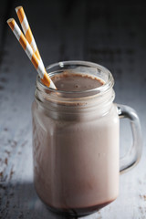 A glass jar with chocolate milk drink	