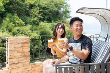 別荘の庭でビールを飲むカップル