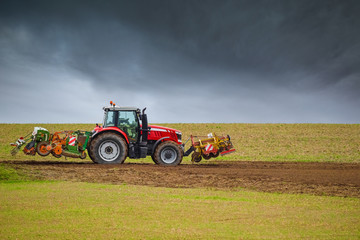 Fototapeta premium beautiful landscape with a farmer plowing his fields before the storm