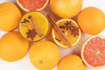 Fresh orange cinnamon star anise clove spice juice in glass on white  background 
