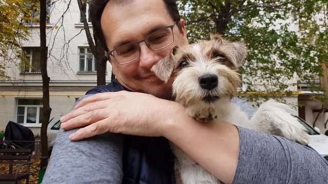 White puppy with adult man outdoors