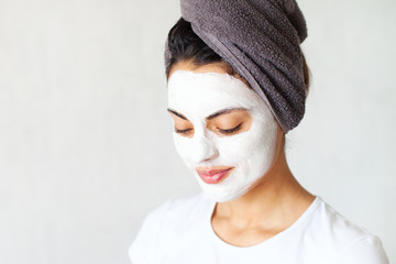 Smiling woman applying clay mask