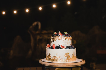 Stylish modern wedding cake. Beautiful dessert decorated with fresh fruit.