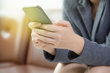 Woman using smartphone sitting on sofa