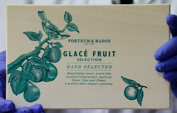 A worker displays a box of glace fruits to export to London's upmarket department store Fortnum & Mason at the Cruzilles factory in Clermont-Ferrand