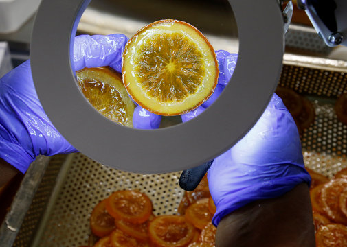 A worker checks candied slices of orange before export to Japan at the Cruzilles factory in Clermont-Ferrand