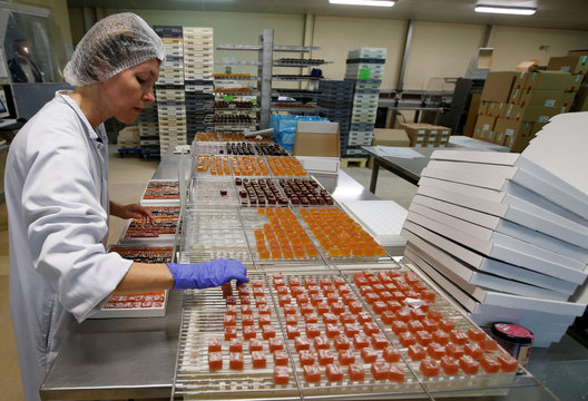 A woker prepares boxes of glace fruits and fruit jelly for export at the Cruzilles factory in Clermont-Ferrand