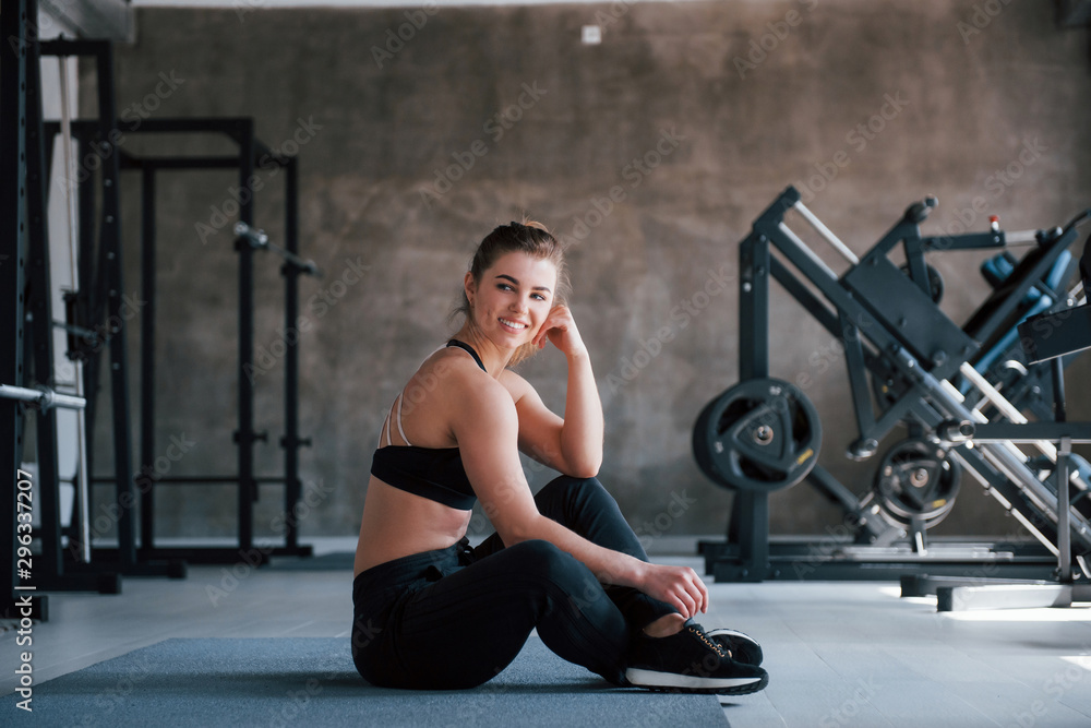 Wall mural Modern sports. Photo of gorgeous blonde woman in the gym at her weekend time