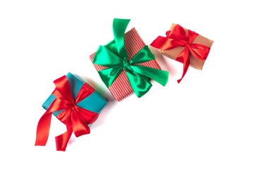 Bright christmas gifts with colorful atlas ribbons isolated on white