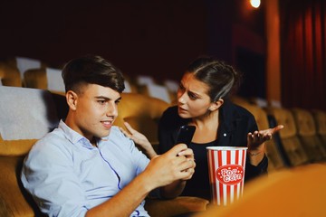 young couple watching movie in cinema