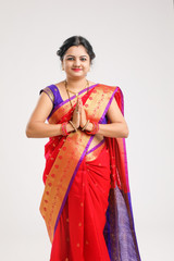  young Indian woman wearing  Sari  and showing a welcome gestures, isolated on white background