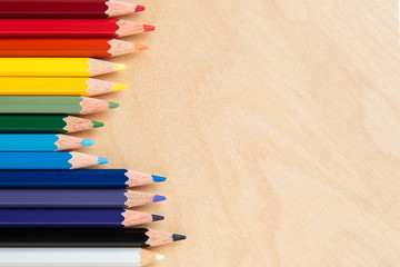 Colored pencils on wooden background