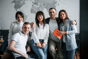 Successful team of young freelancers posing for the photography after work