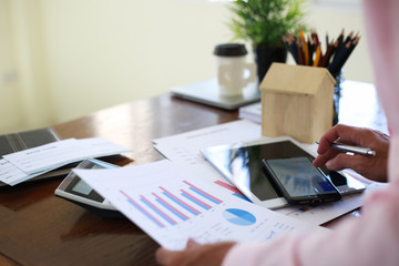 businessmen are using a pen pointing to the statistics on the graph to analyze their revenue.concept