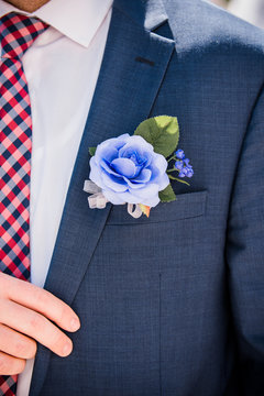 Violey floral boutonniere against navy blue blazer