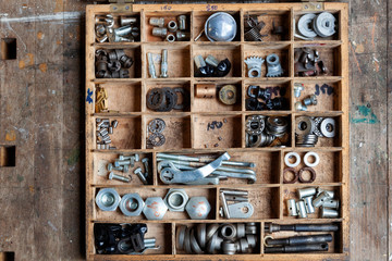 Old wooden box with an assortment of hardware for industrial use