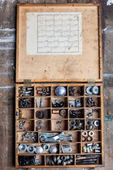 Old wooden box with an assortment of hardware for industrial use