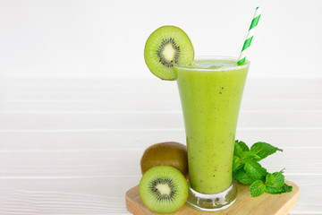 Kiwi yogurt fruit juice smoothie and green kiwi juice drink healthy delicious taste in a glass for weight loss on a white wooden background.