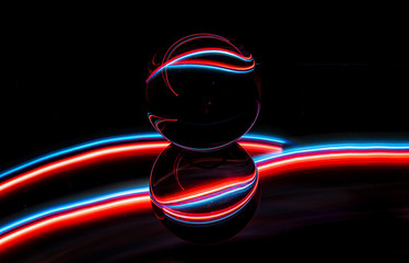 Glaskugel mit rot-blauen Streifen auf schwarzem Hintergrund