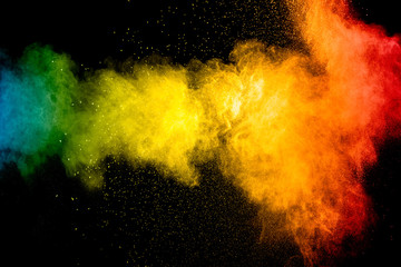 Multicolored powder explosion on black background.Colorful red yellow blue splash cloud on...
