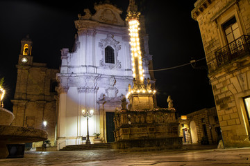 The church of Sant'Andrea Apostolo, in Presicce, with the column decorated with Christmas lights....