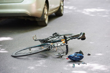 Drunk driving. Bicycle and silver colored car accident on the road at forest at daytime