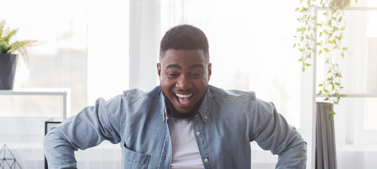 Portrait of ecstatic black guy looking at something with excitement