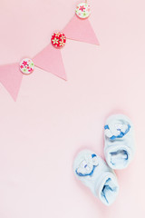 Newborn flat lay postcard. Baby booties shoes for boy and girl on a blue pink background. Congratulations on the birth of a newborn baby with copy space.