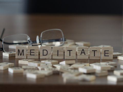 The concept of Meditate represented by wooden letter tiles
