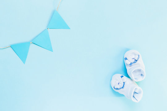 Newborn flat lay postcard. Baby booties shoes for boy and girl on a blue pink background. Congratulations on the birth of a newborn baby with copy space.
