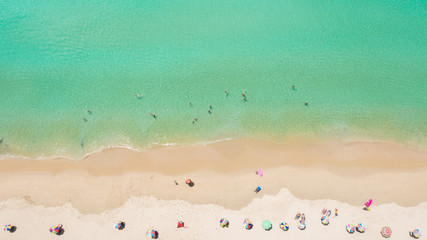 Aerial view of Surin beach, Phuket, Thailand, Surin beach is a very famous tourist destination in Phuket, Tropical sandy beach with turquoise clear water, Tourist on the beach and colorfull umbrellas.