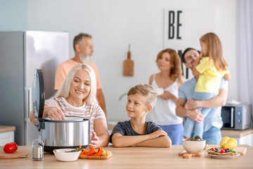 Mature woman with grandson cooking in kitchen