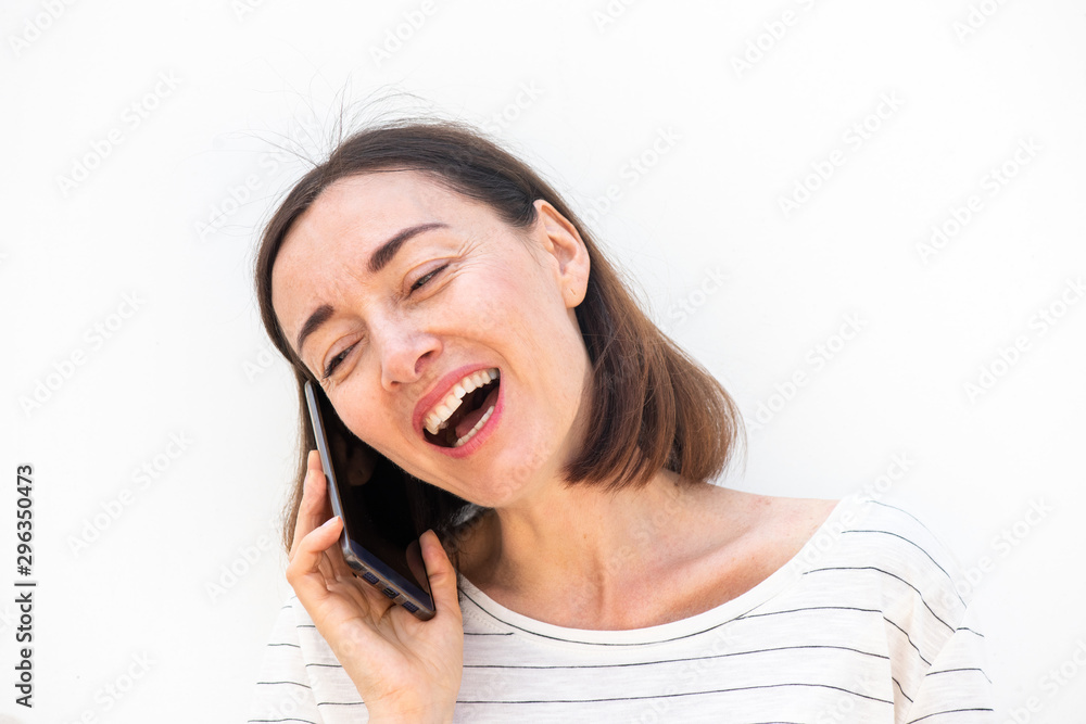 Wall mural happy middle aged woman talking with mobile phone by white background