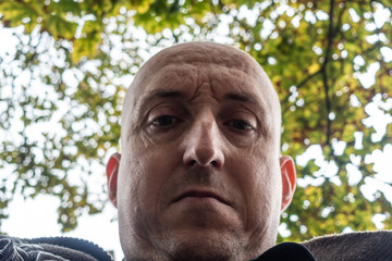 A self portrait of a middle aged man seen from below