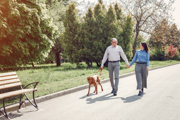 Couple in a forest. Adult pair with cute dogs. Lady in a blue shirt