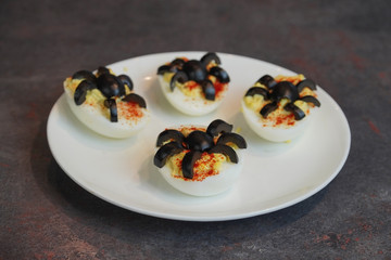 Spider Deviled Eggs on a White Plate. Healthy Halloween Snack