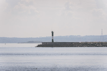 Fototapeta premium White lighthouse in the seaport