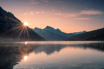 Foto auf Acrylglas Dämmerung Sonnenaufgang am Berg mit Nebel im Medizinsee bei Jasper