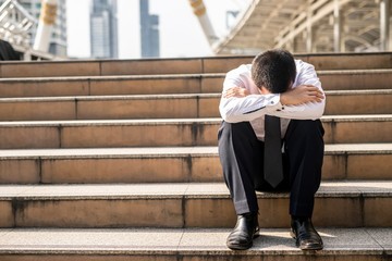 ํimage of young man sitting on a stairway,worry