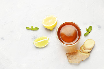 cup of hot tea with ginger, lemon and mint isolated on a white background